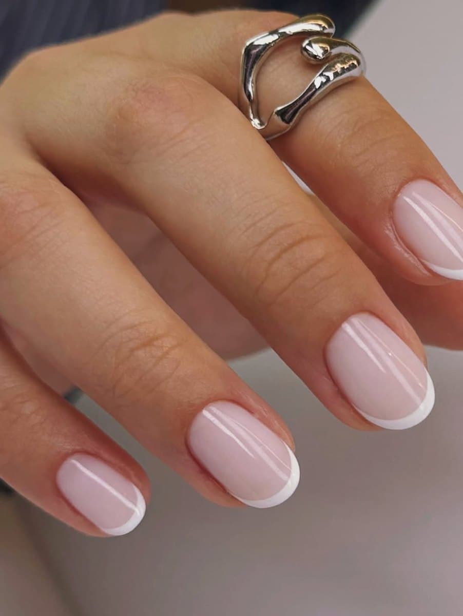A finished Russian manicure with a clean cuticle seal and a soft pink finish.