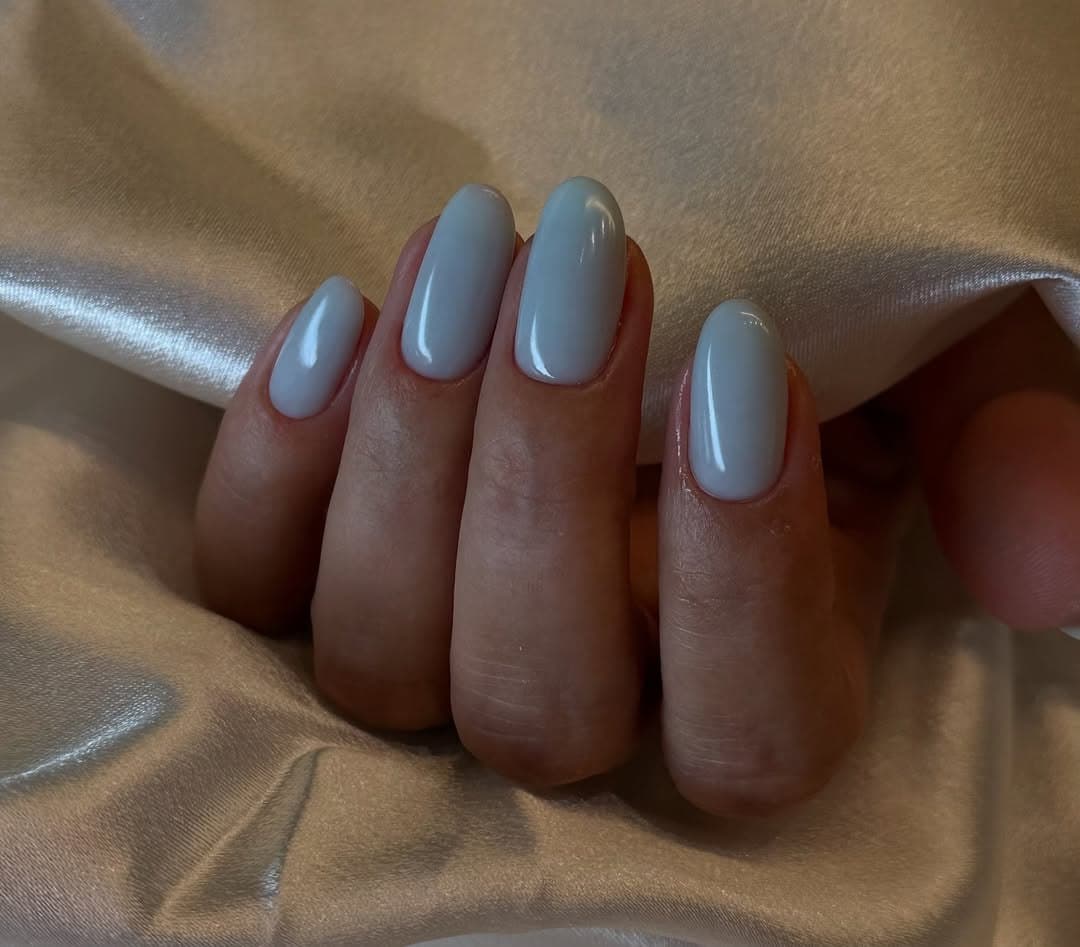 A soft slate-blue gel manicure with a clean finish.