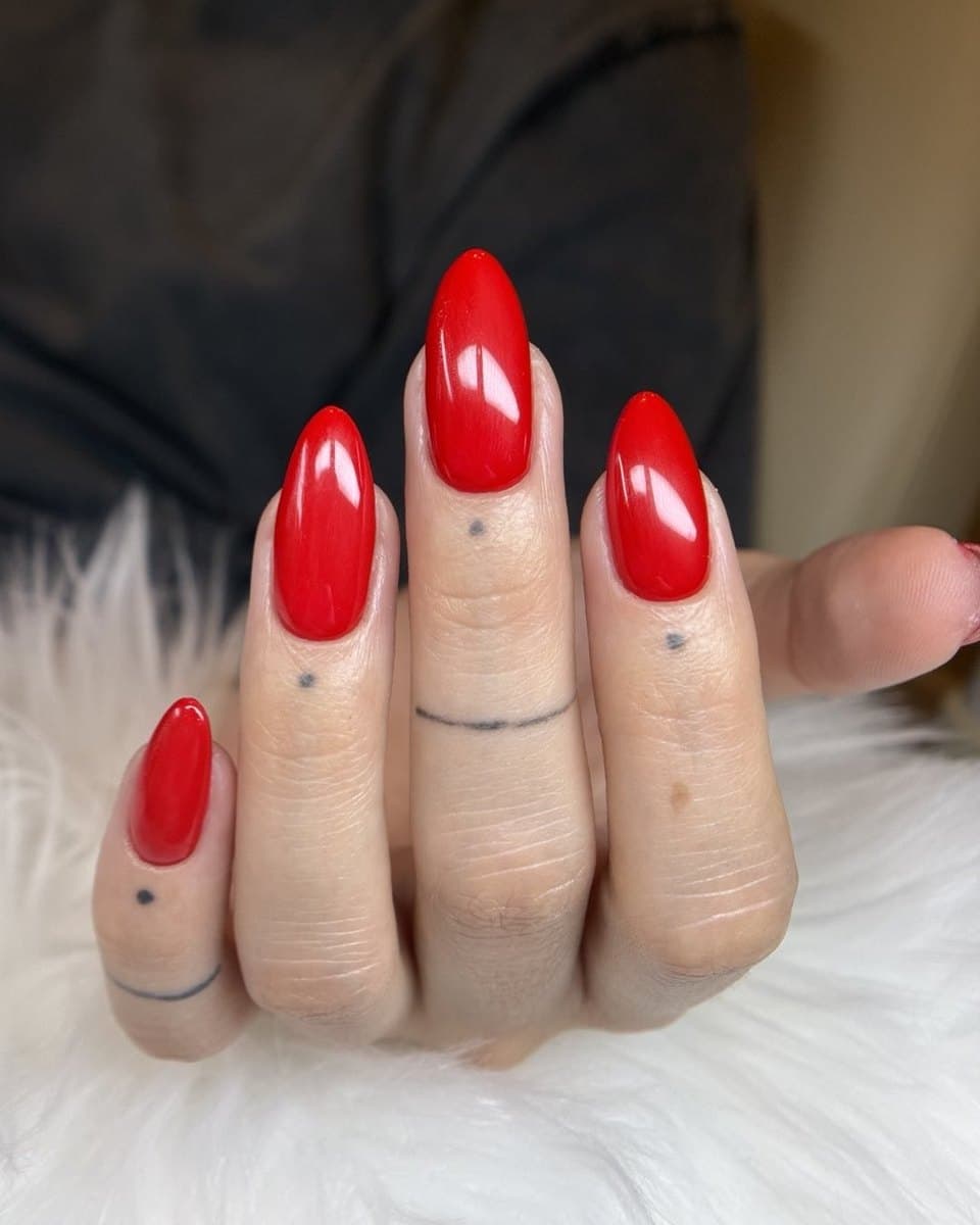 Long red almond nails with a high-gloss finish.