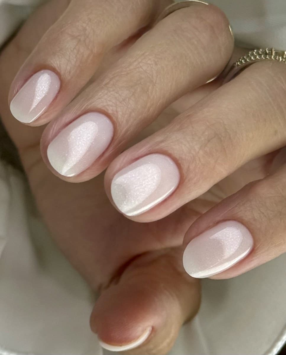 A pearl chrome manicure on short square nails.