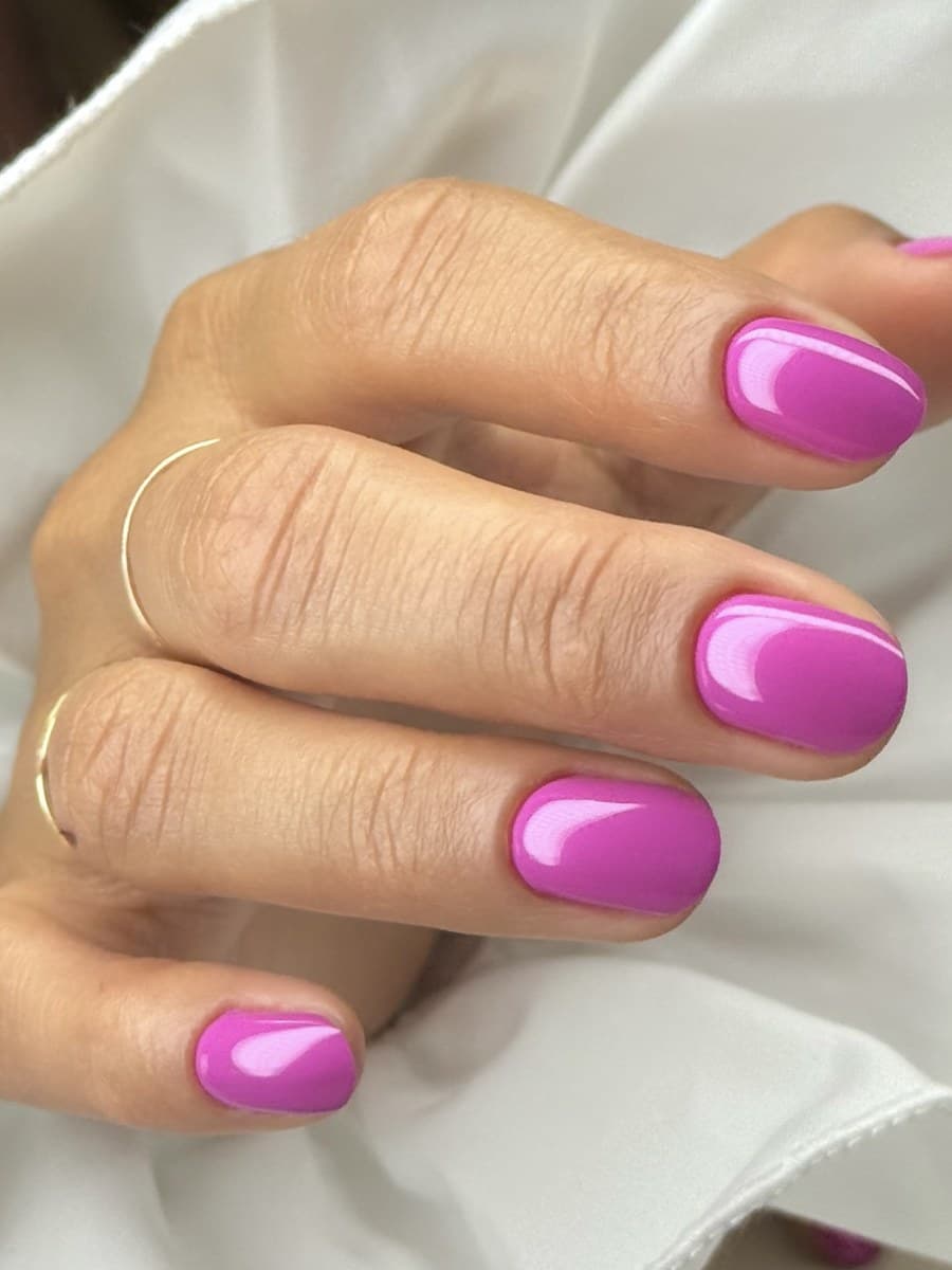 Glossy hot-pink gel on almond nails.