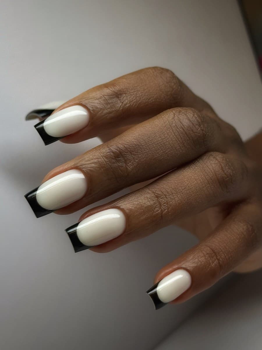 Bold black-and-white French tips on square extensions.