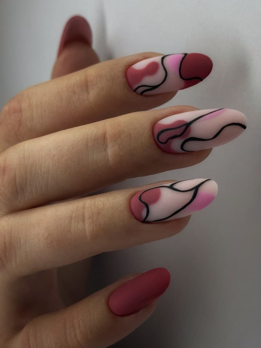 Pink almond nails with black line-art swirls.