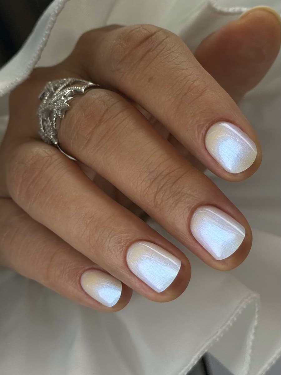 A blue-and-white cloud marble design on short nails.