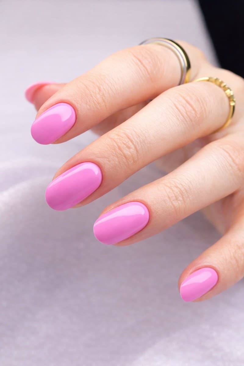 Bright glossy pink gel on almond nails.