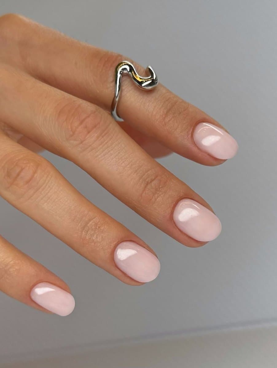 A soft pink-to-white ombré across a manicured set.